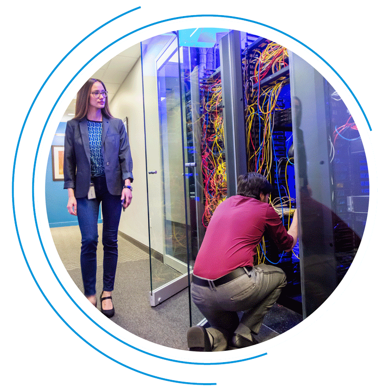 Woman surveys man fixing a data storage system Woman surveys man fixing a data storage system