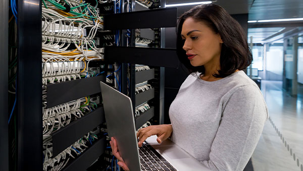 woman holding a laptop while checking on technology woman holding a laptop while checking on technology