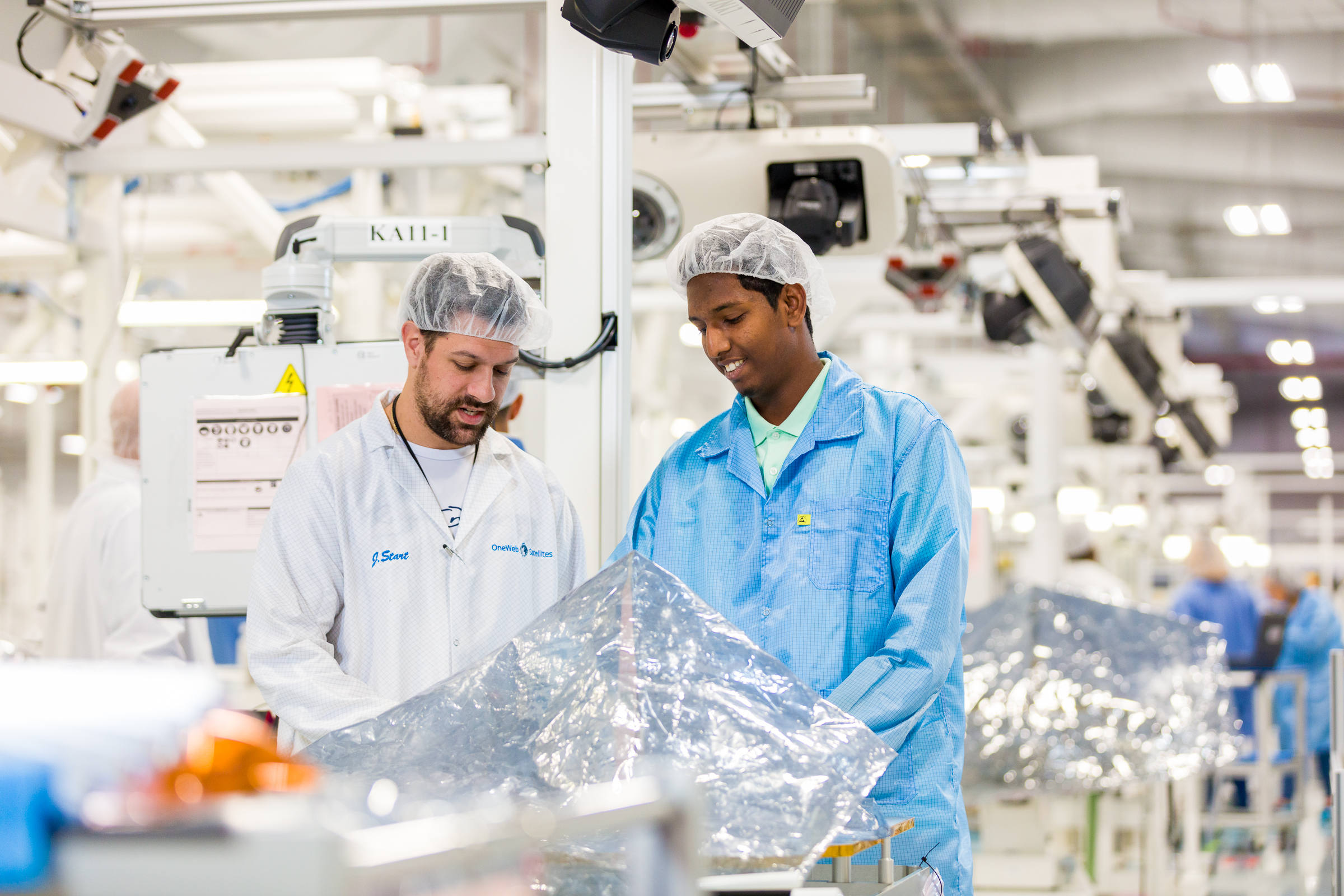 Two satellite engineers working in manufacturing factory